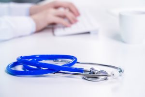 business-concept-young-female-doctor-woman-working-office-with-computer-typing-electronic-medical-record-white-table-background-close-up-copy-space (1)