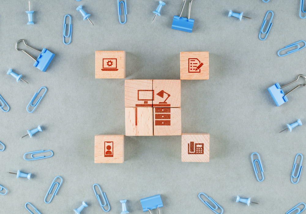 conceptual-business-office-with-wooden-blocks-with-icons-paperclips-binder-clips-top-view